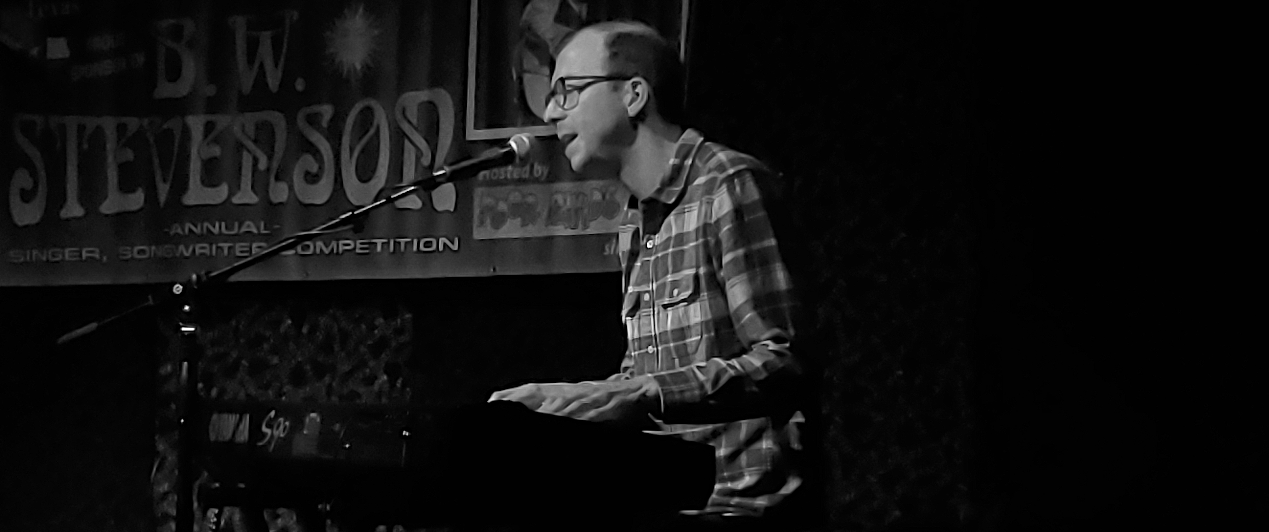 Brent Pendergraft playing the keyboard and singing into a microphone